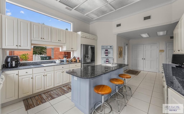 2301 Riverside Dr, Harlingen, TX 78550 - kitchen with double oven, a breakfast bar area, a sink, visible vents, and stainless steel refrigerator with ice dispenser