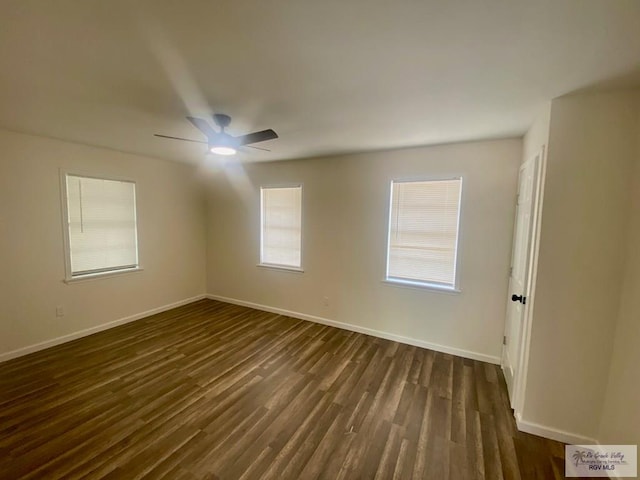 spare room with baseboards, a ceiling fan, and dark wood-style floors