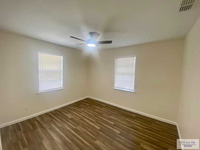 empty room featuring baseboards, a ceiling fan, dark wood-type flooring, and visible vents