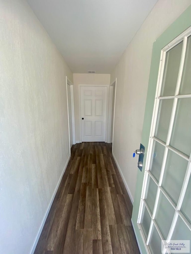 corridor with visible vents, baseboards, and wood finished floors