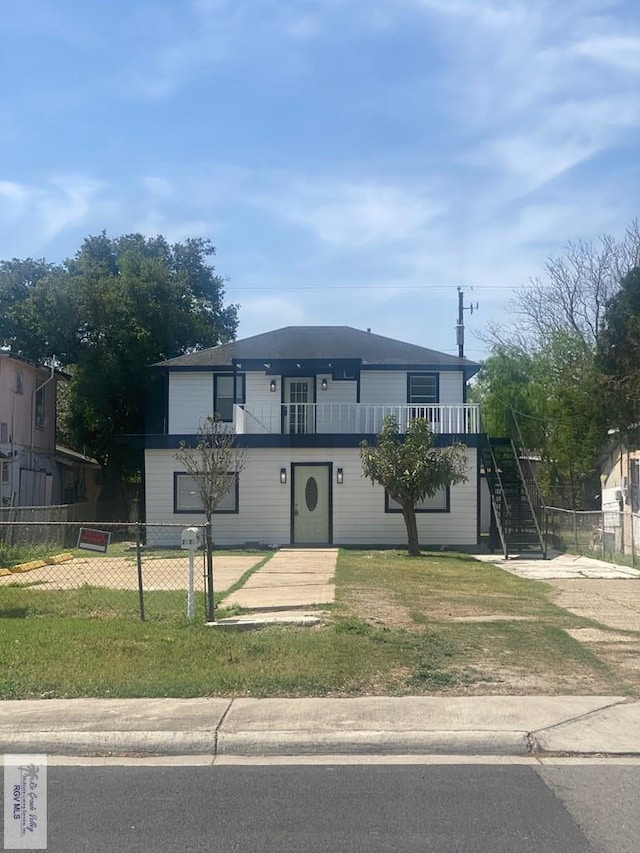 view of front of house featuring a front yard, stairs, and a fenced front yard