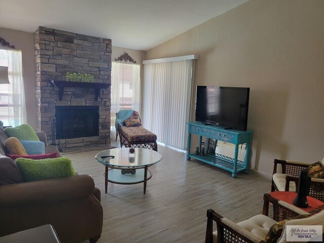 living room with a fireplace, hardwood / wood-style floors, and lofted ceiling