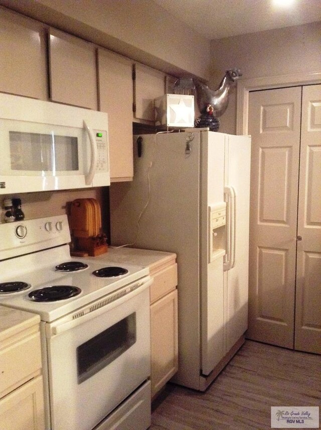 kitchen featuring white appliances and dark hardwood / wood-style floors