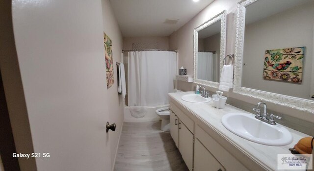 full bathroom featuring vanity, shower / bath combo, and toilet