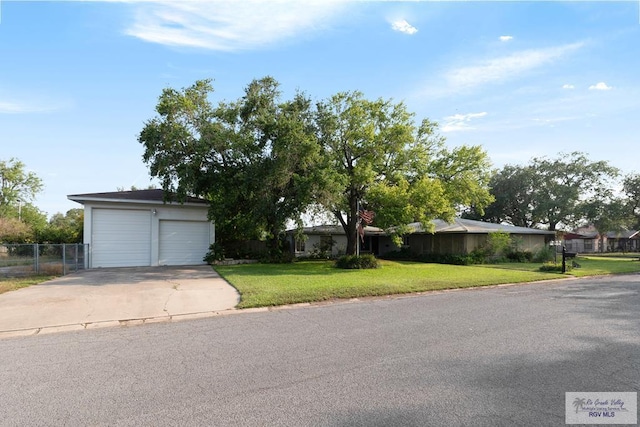 ranch-style house featuring a garage and a front lawn