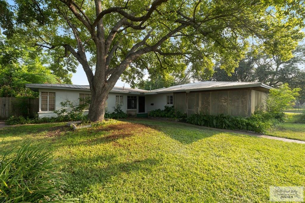 rear view of property featuring a lawn