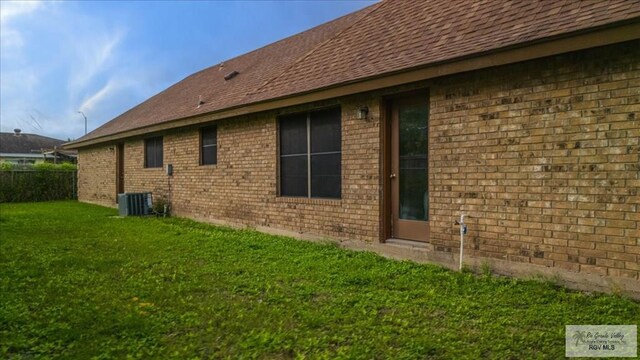 1544 W San Marcelo Blvd, Brownsville, TX 78526 - back of house with fence, a shingled roof, a yard, and brick siding