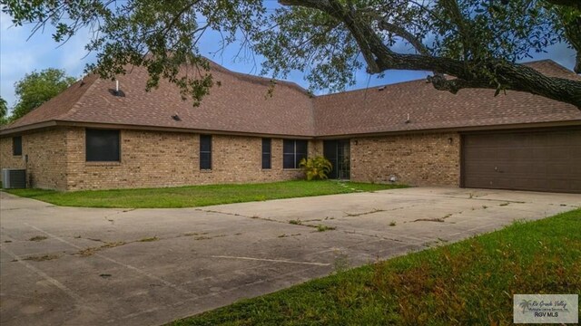 1544 W San Marcelo Blvd, Brownsville, TX 78526 - ranch-style house with roof with shingles, brick siding, a front lawn, concrete driveway, and an attached garage