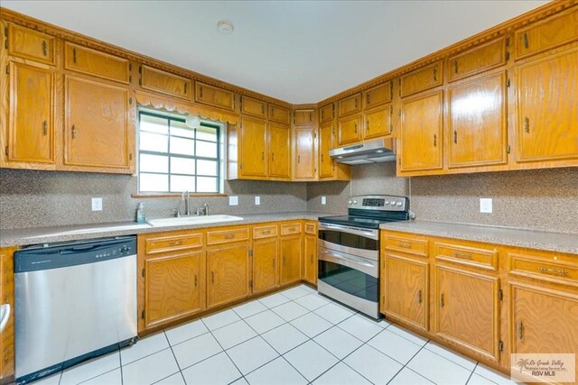 1544 W San Marcelo Blvd, Brownsville, TX 78526 - kitchen featuring a sink, light countertops, brown cabinetry, stainless steel appliances, and under cabinet range hood