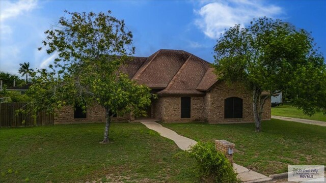 1544 W San Marcelo Blvd, Brownsville, TX 78526 - view of front of home featuring fence, brick siding, and a front yard