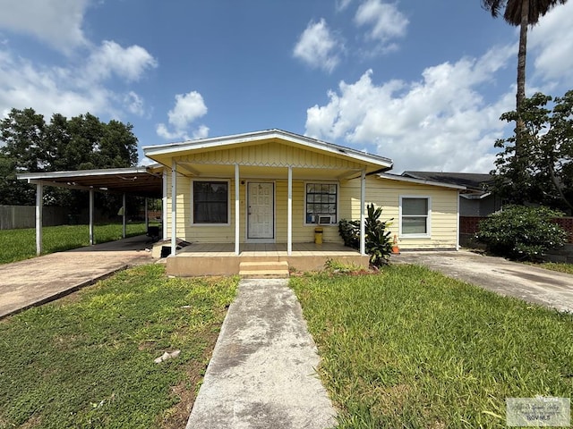 165 Johns Ave, Brownsville, TX 78521 - view of front of home featuring concrete driveway, a front lawn, a porch, and a carport