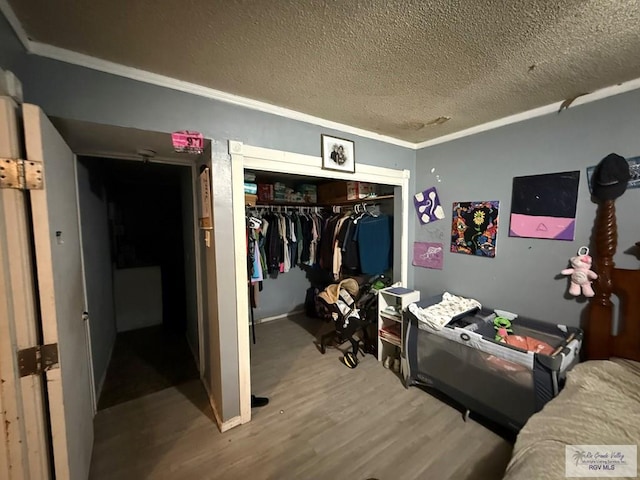 165 Johns Ave, Brownsville, TX 78521 - bedroom with wood finished floors, a closet, a textured ceiling, and ornamental molding