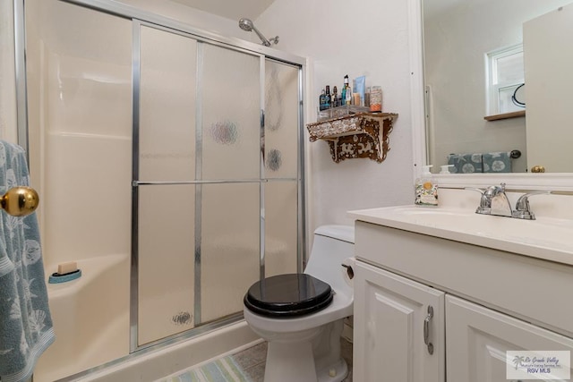 bathroom featuring tile patterned floors, vanity, an enclosed shower, and toilet