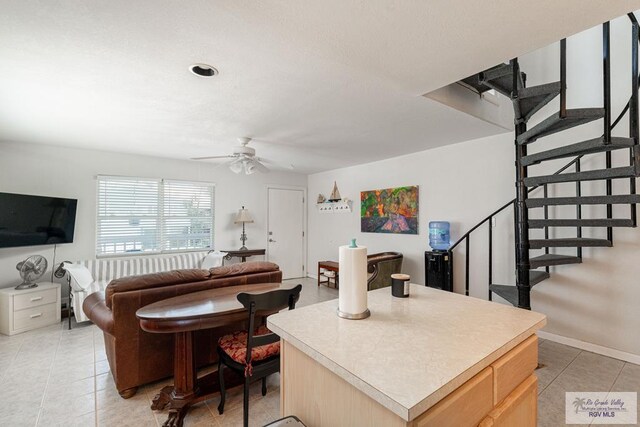 living room with ceiling fan and light tile patterned floors