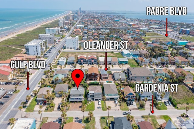 birds eye view of property with a water view and a beach view