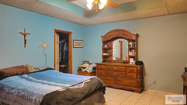 bedroom featuring light tile patterned floors, a textured ceiling, and ceiling fan