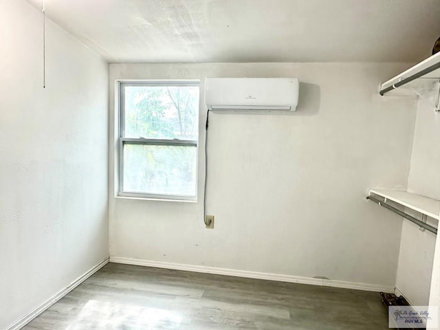 interior space with an AC wall unit and hardwood / wood-style floors