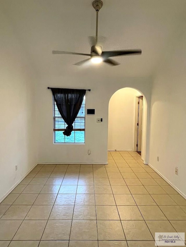 tiled spare room featuring ceiling fan