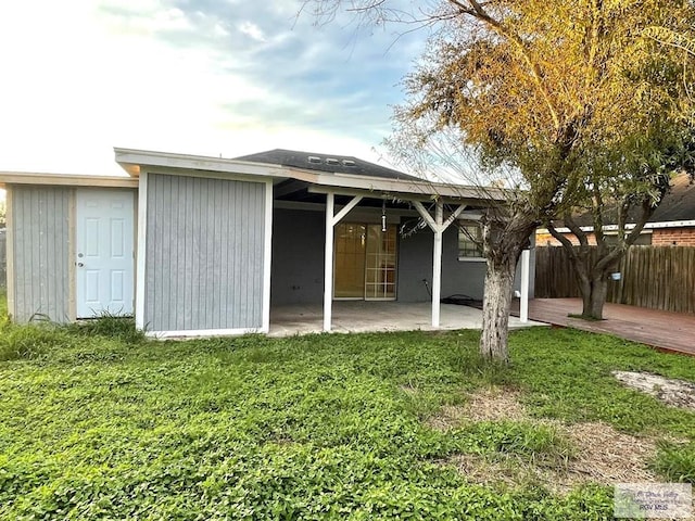 rear view of property featuring a patio area and a yard