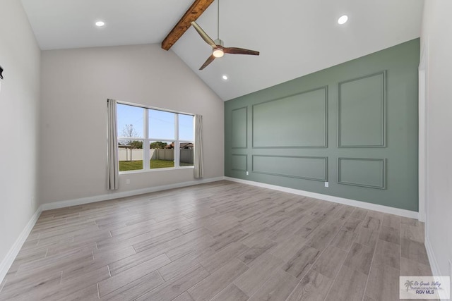 spare room featuring high vaulted ceiling, a decorative wall, a ceiling fan, beam ceiling, and light wood-type flooring