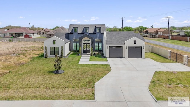 modern inspired farmhouse featuring driveway, an attached garage, fence, and a front yard