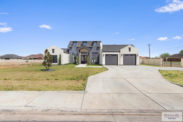 view of front of home featuring driveway, an attached garage, fence, and a front yard