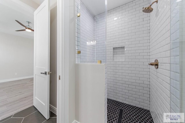 full bathroom with baseboards, ceiling fan, tile patterned floors, and tiled shower