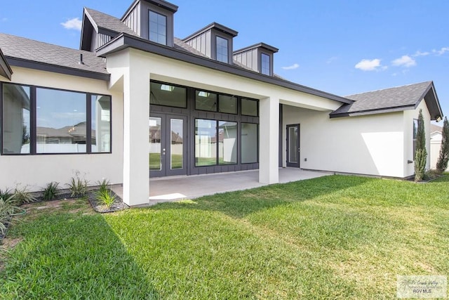 rear view of house featuring stucco siding, a patio area, french doors, and a yard