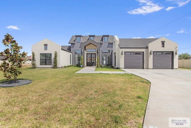 view of front of house featuring roof with shingles, french doors, driveway, a front lawn, and a garage