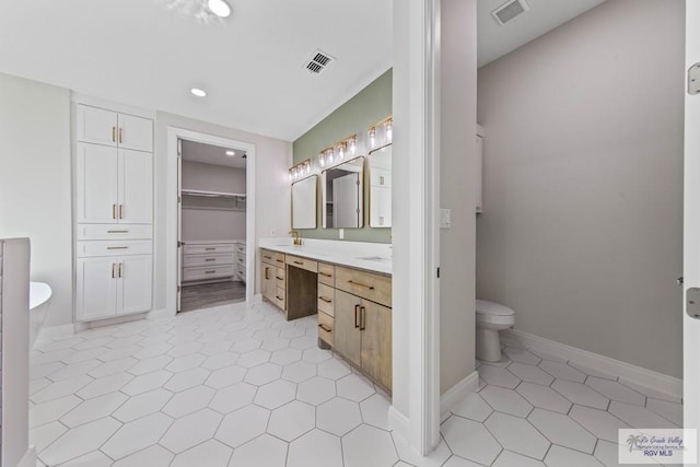 bathroom featuring a soaking tub, baseboards, visible vents, and vanity