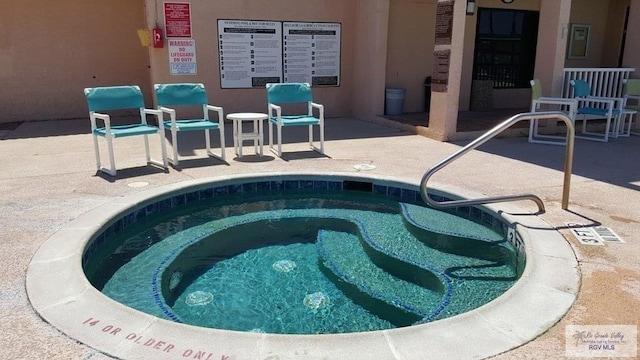 view of pool with a patio area and a hot tub