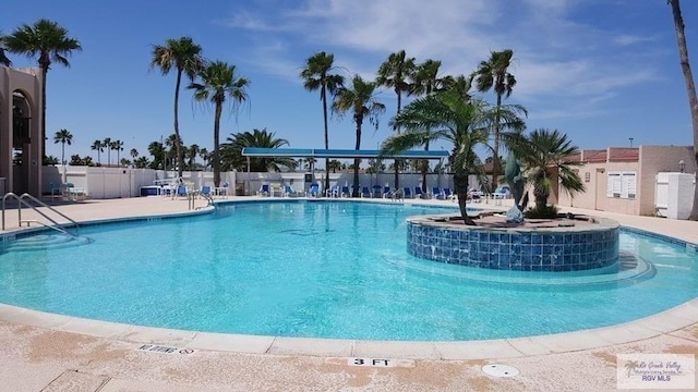 community pool featuring a patio area and fence