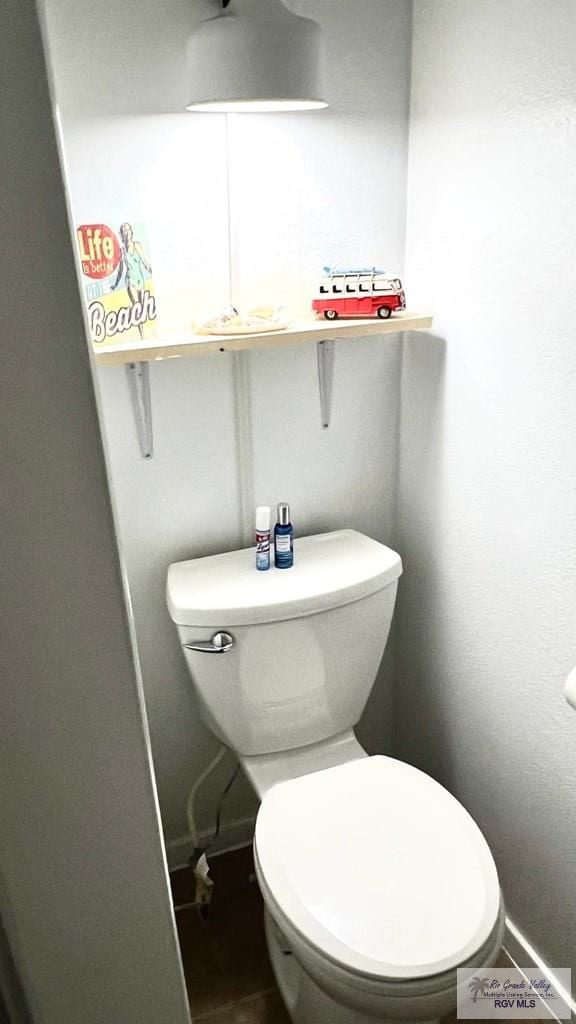 bathroom with toilet and baseboards