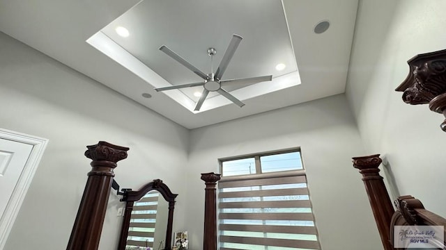 details featuring ceiling fan and a tray ceiling