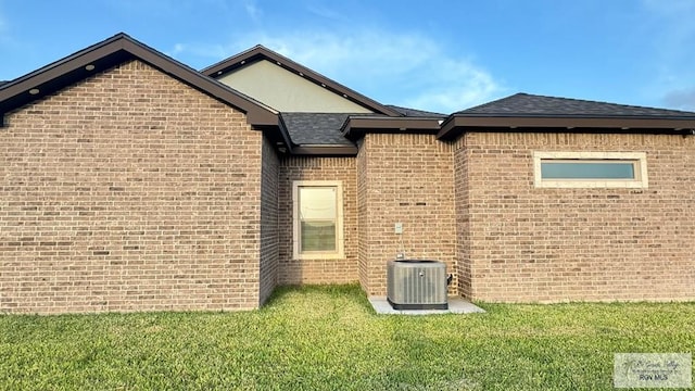 rear view of property featuring central AC unit and a yard