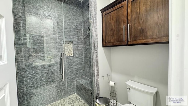 bathroom featuring an enclosed shower and toilet