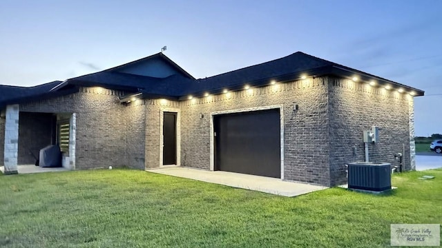 back house at dusk featuring a lawn