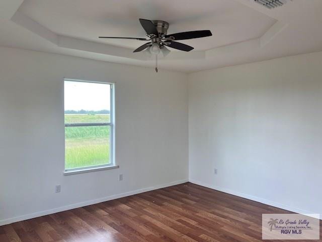 1056 E Mile 11, Weslaco, TX 78599 - unfurnished room with a tray ceiling, wood finished floors, and ceiling fan