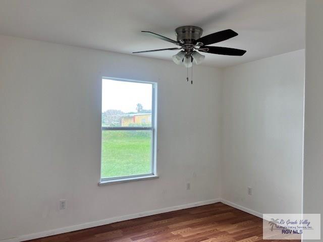 1056 E Mile 11, Weslaco, TX 78599 - spare room featuring plenty of natural light, wood finished floors, and ceiling fan