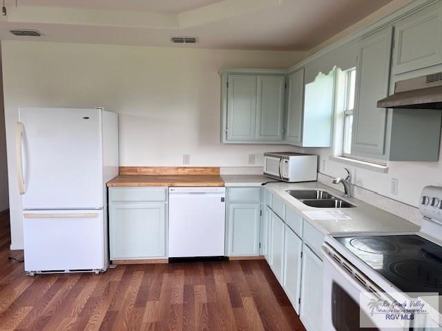 1056 E Mile 11, Weslaco, TX 78599 - kitchen with white appliances, under cabinet range hood, dark wood-style flooring, and light countertops