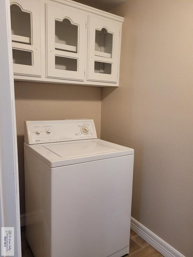 laundry area with washer / clothes dryer, dark wood-style flooring, cabinet space, and baseboards