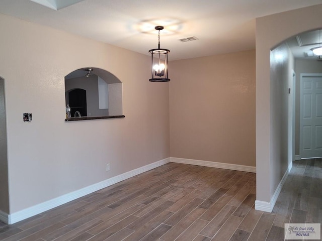 unfurnished dining area featuring dark wood-type flooring, visible vents, and baseboards