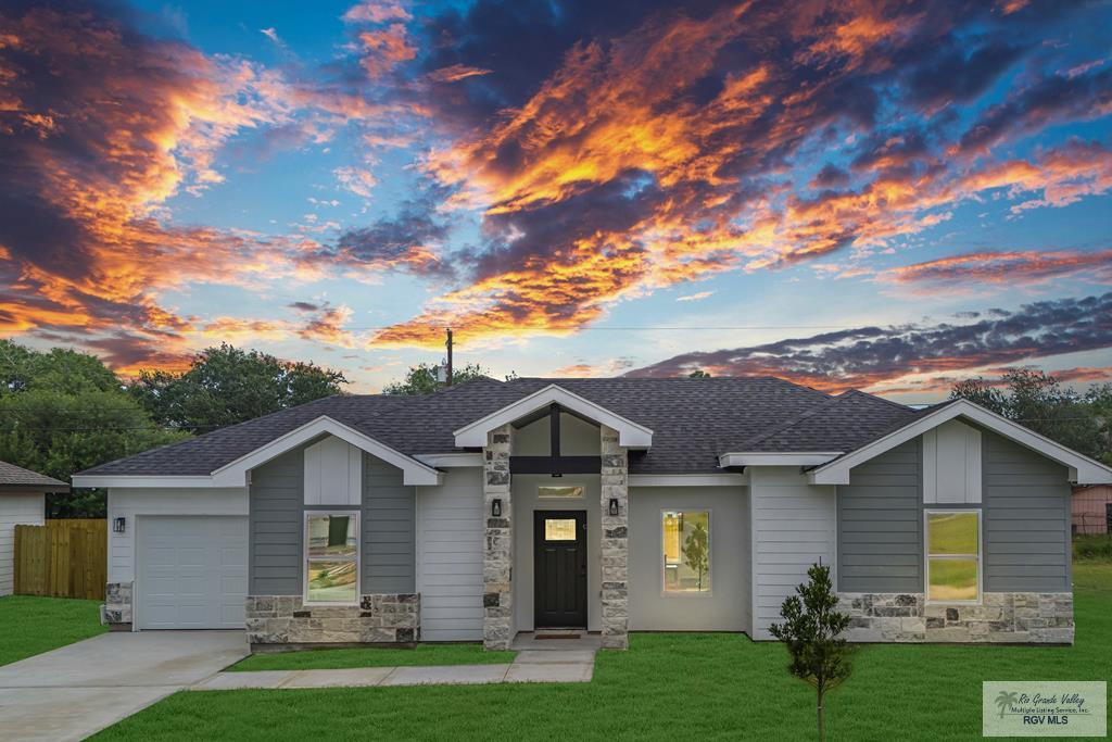 view of front of house featuring a garage and a lawn