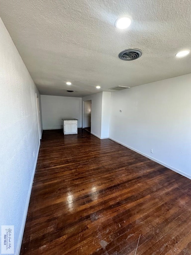 interior space featuring a textured ceiling and dark hardwood / wood-style floors