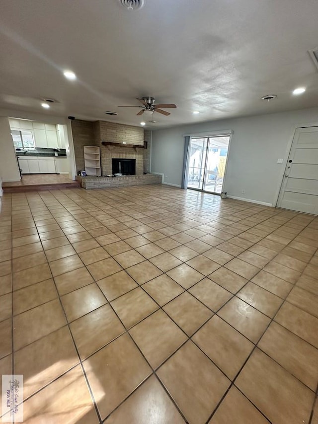 unfurnished living room featuring light tile patterned floors, a brick fireplace, and ceiling fan