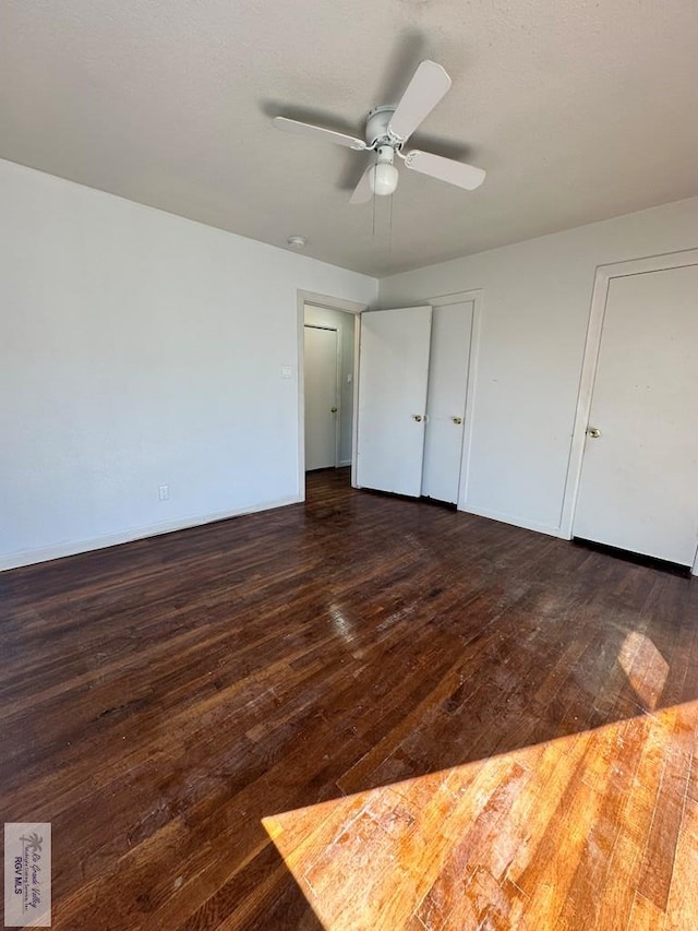 unfurnished bedroom with ceiling fan and dark hardwood / wood-style flooring