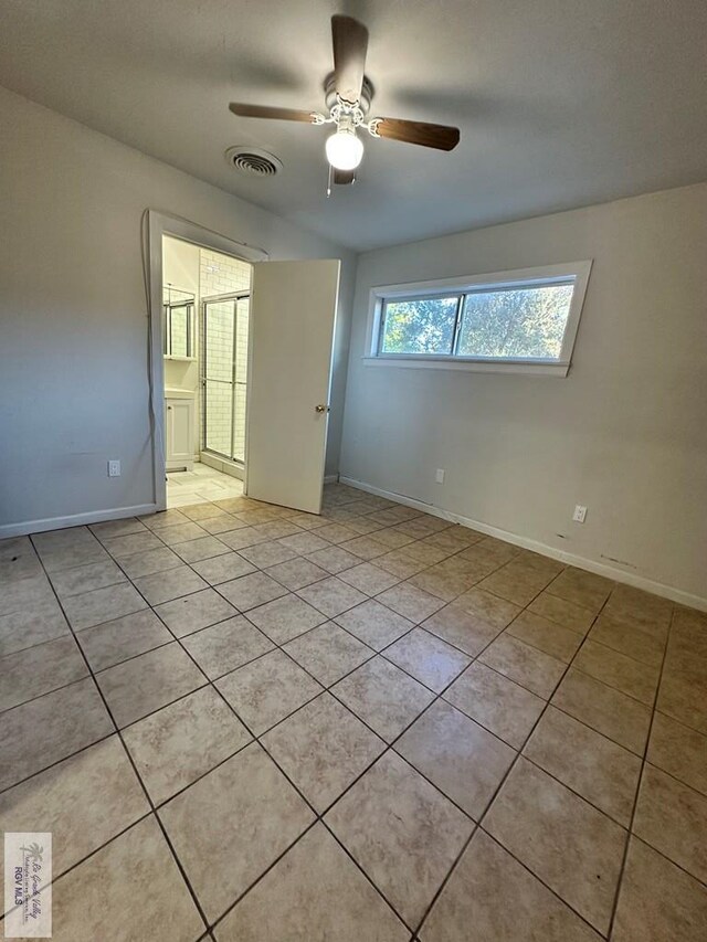 spare room with ceiling fan and light tile patterned flooring