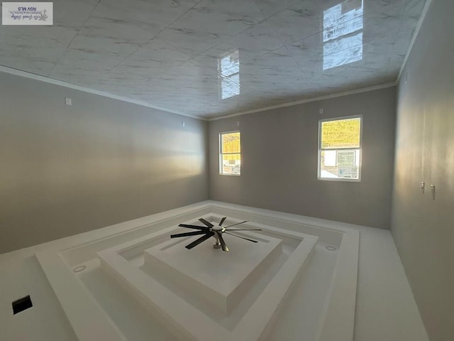 empty room featuring ornamental molding and plenty of natural light