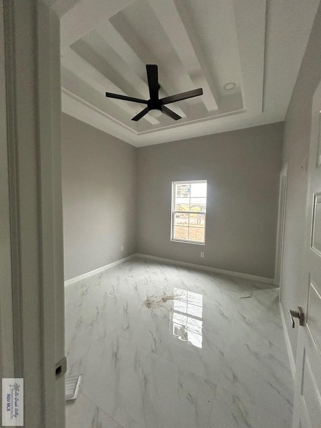 unfurnished room featuring ceiling fan and a tray ceiling