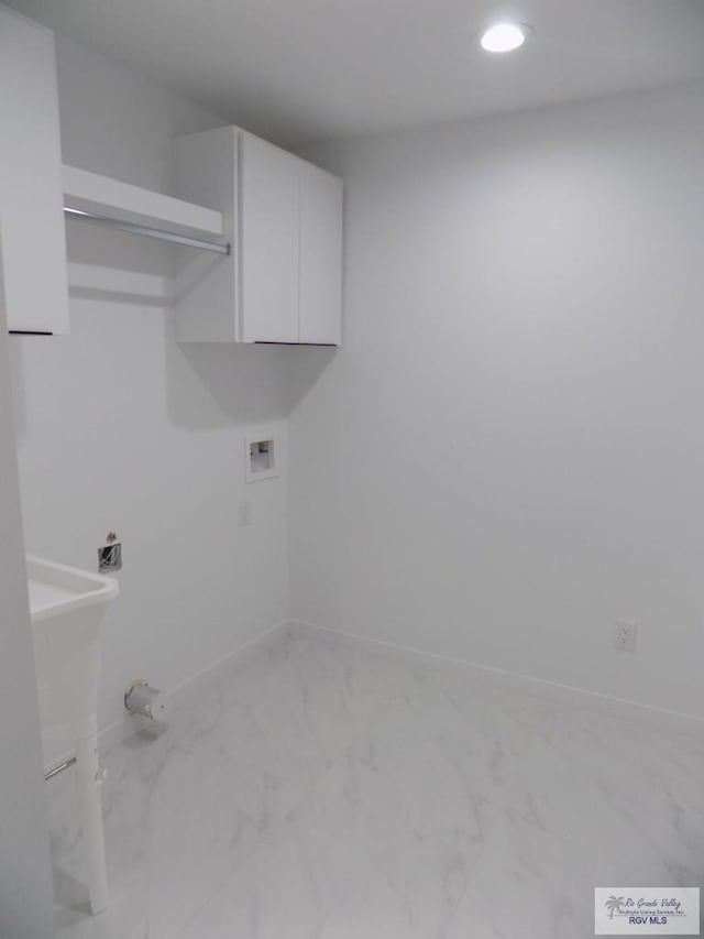 washroom with hookup for a washing machine and cabinets